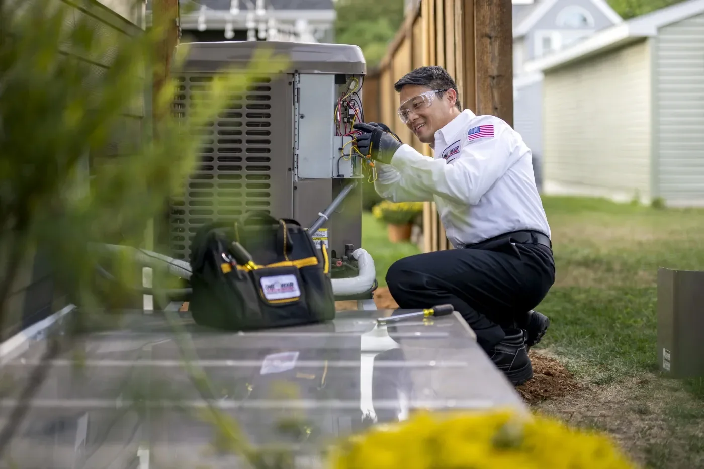 HVAC technician servicing an outdoor residential air conditioning unit